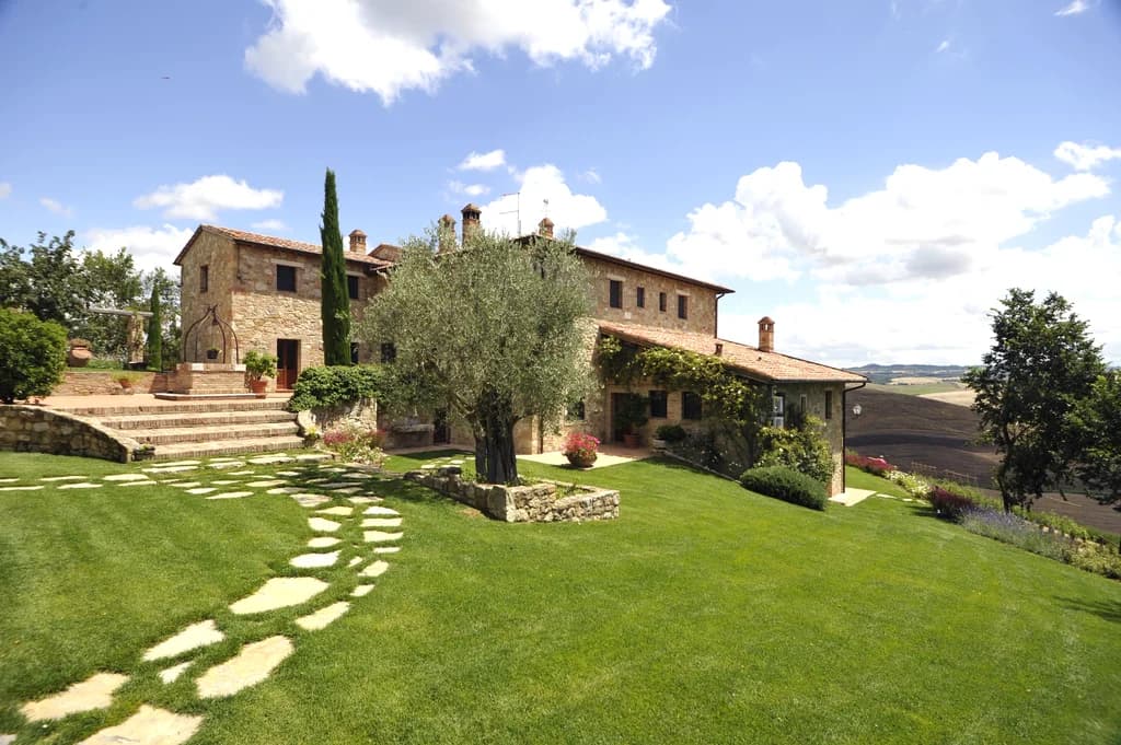 Il Pozzo historic stone farmhouse exterior with terracotta roof, San Quirico d'Orcia, Italy