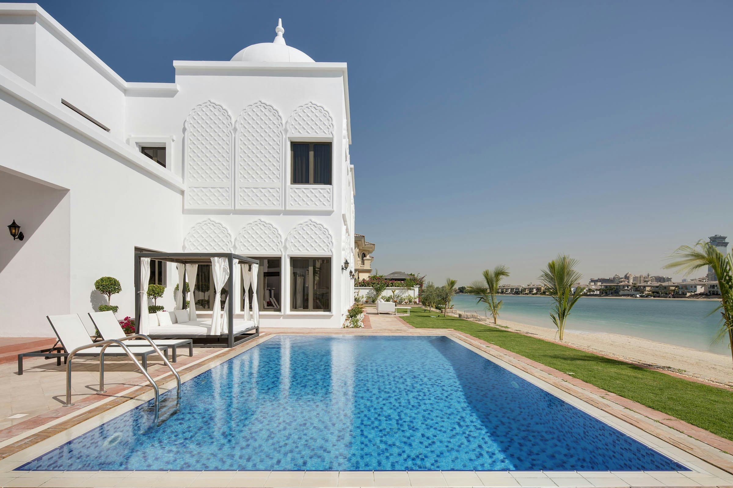 On the Palm beachfront villa exterior with pool and Dubai skyline, Palm Jumeirah, UAE