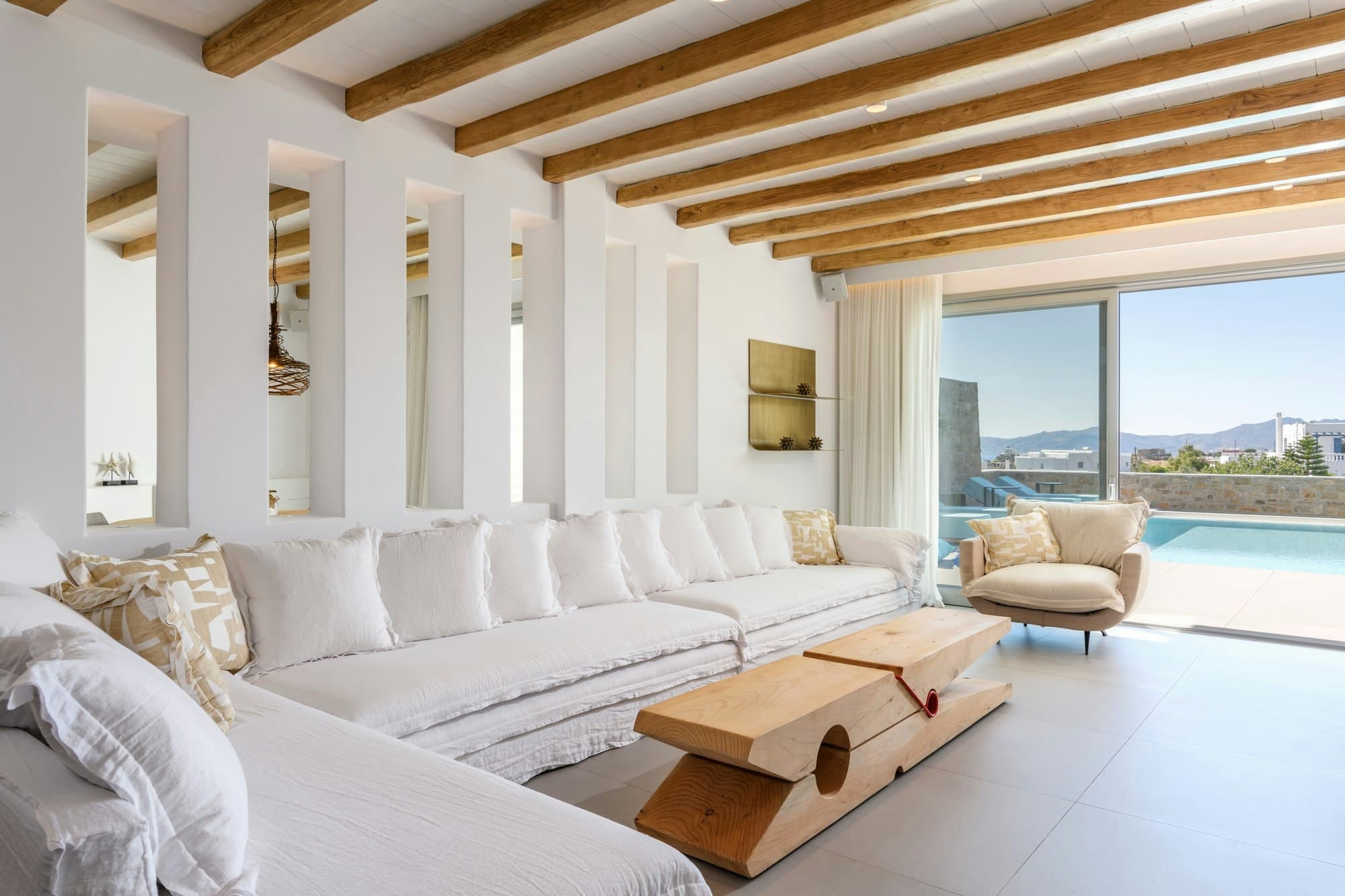 Cycladic Sunset Stay living room with white sofa and pool views, Mykonos, Greece