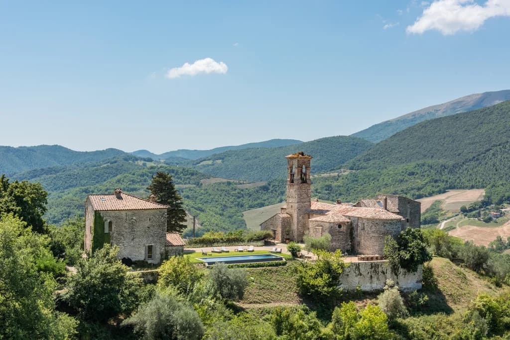 Colle Alto villa aerial overview of medieval stone compound and infinity pool, Umbertide, Italy