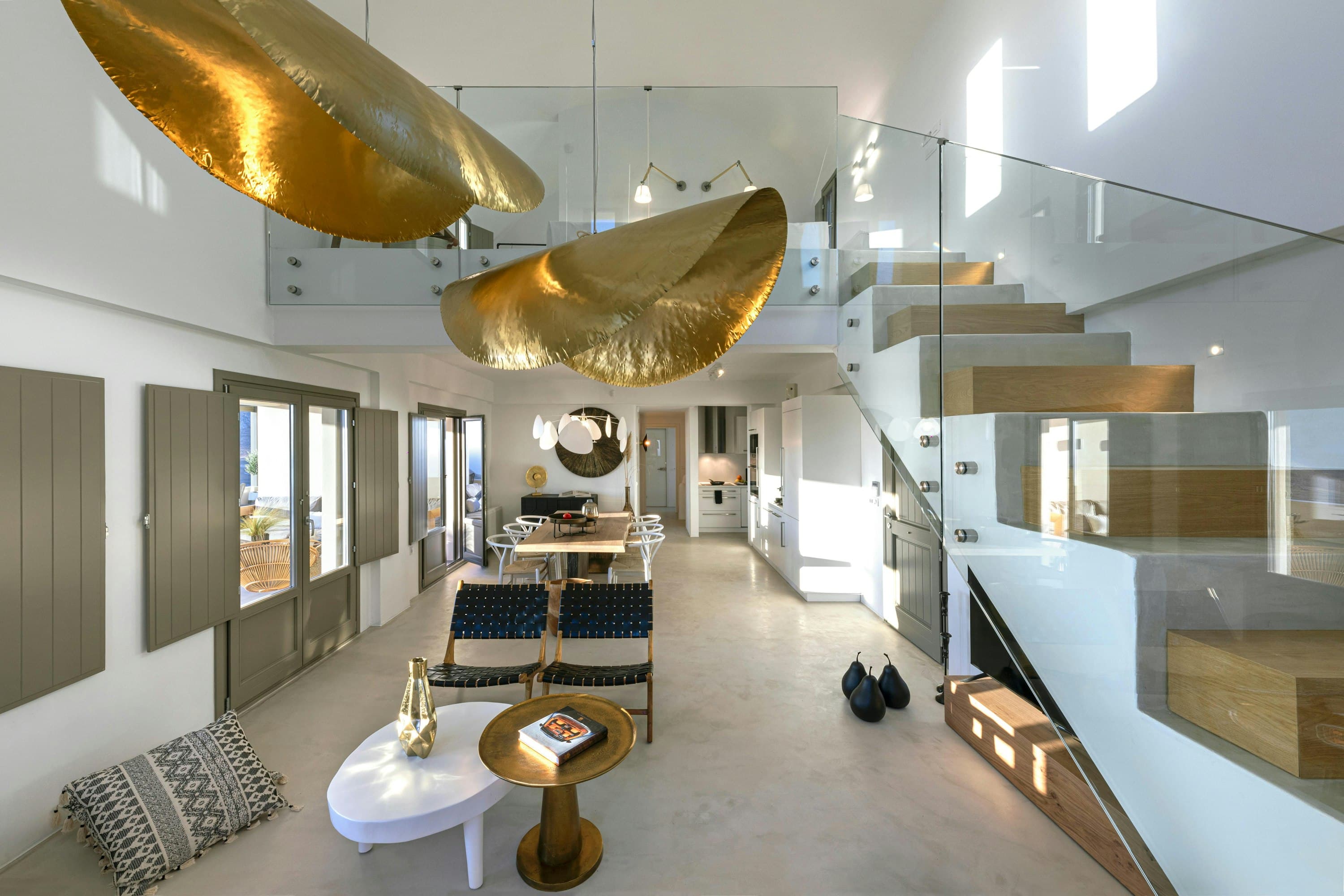 Smile Upon You living room with gold pendant lights and staircase, Pyrgos, Cyclades Islands, Greece
