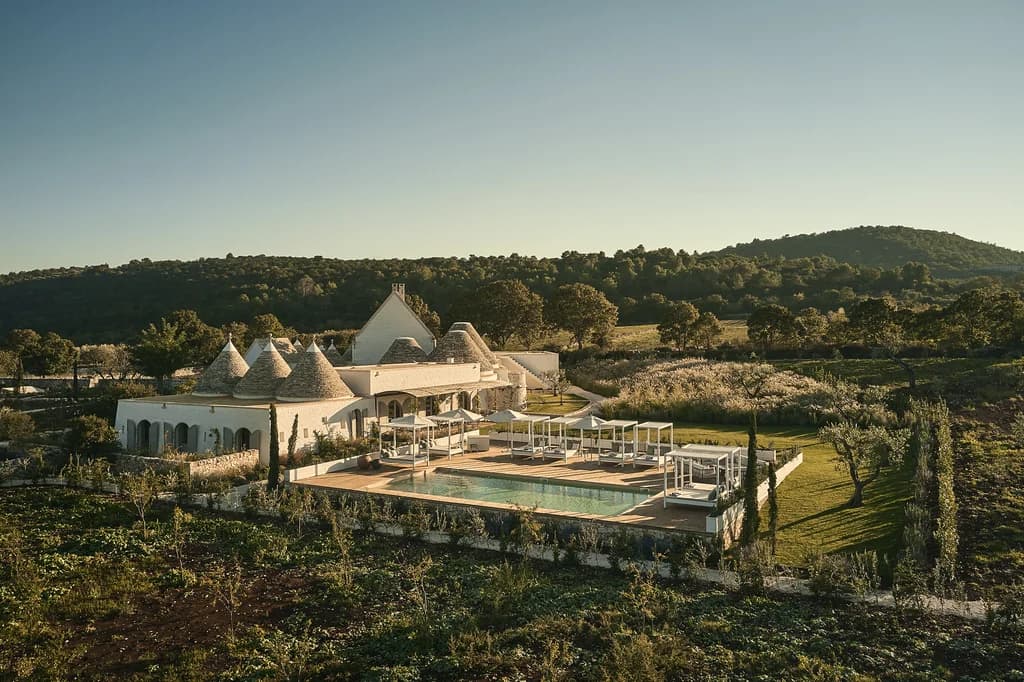 Masseria Giardini aerial exterior with trulli cones and infinity pool, Alberobello, Italy