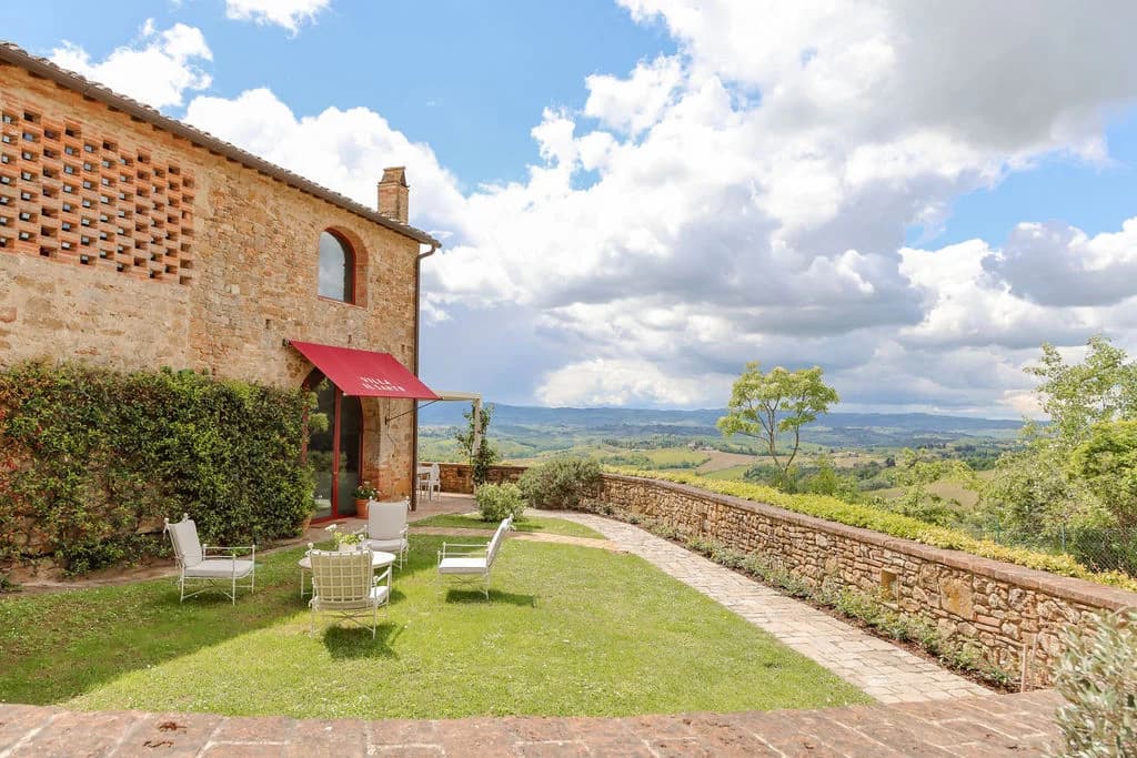 Il Santuario traditional stone guest annexe with red canopy and lawn, Barberino Tavarnelle, Italy