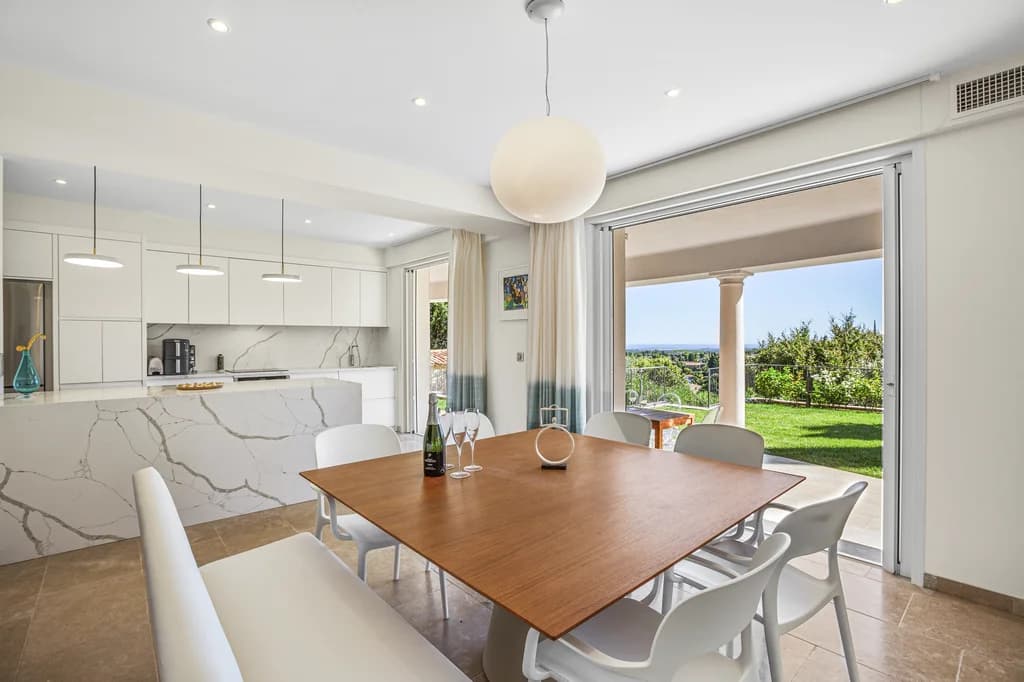 Villa Enchantée kitchen with marble island and dining table for six, Le Rouret, France