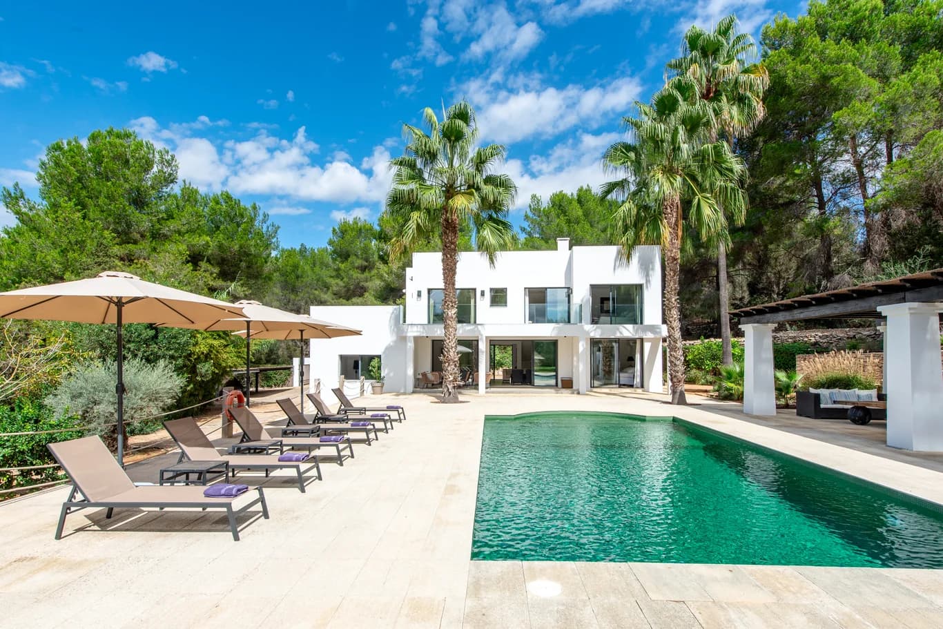 Villa Gertrudis rear exterior with pool surrounded by pine forest, Ibiza, Spain