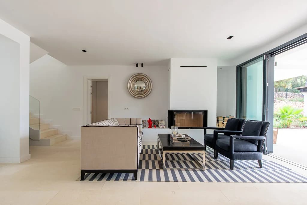 Villa Gertrudis open-plan living room with fireplace and garden views, Ibiza, Spain