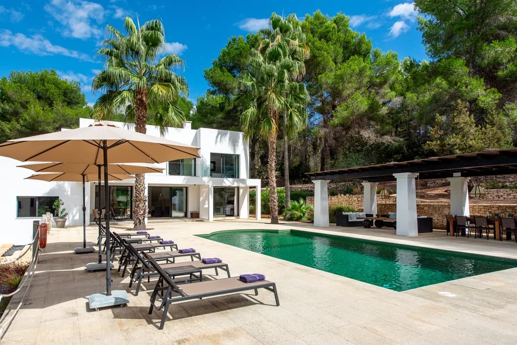 Villa Gertrudis outdoor pool terrace with sun loungers and pergola dining, Ibiza, Spain