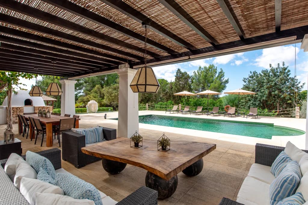 Villa Gertrudis covered pergola lounge with rattan sofas and pool views, Ibiza, Spain