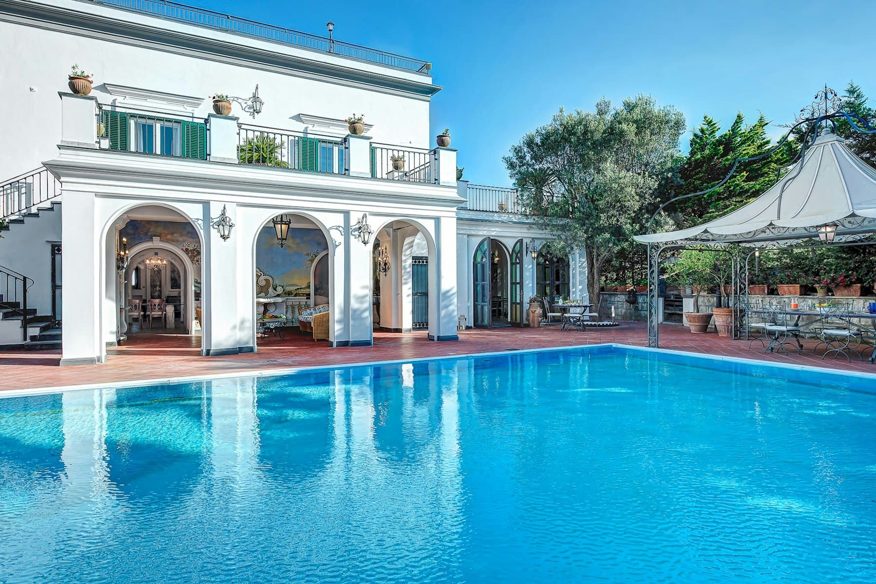Painted Palace villa exterior with arched colonnade and pool, Sant'Agnello, Amalfi Coast, Italy