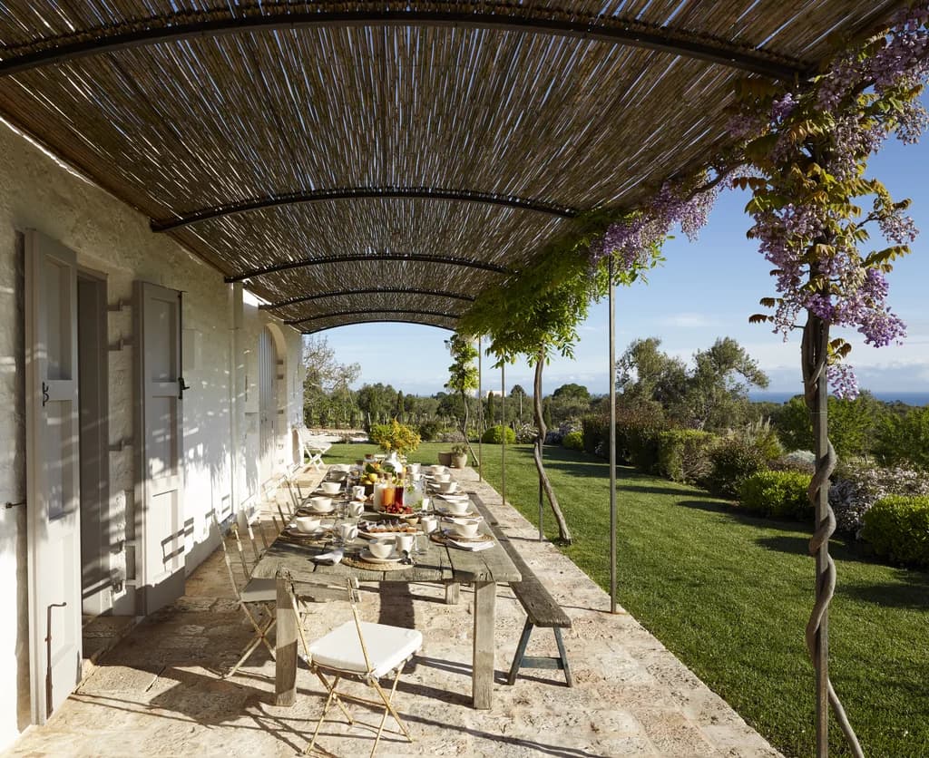Masseria Monopoli outdoor dining terrace under wisteria-draped pergola, Monopoli, Puglia, Italy