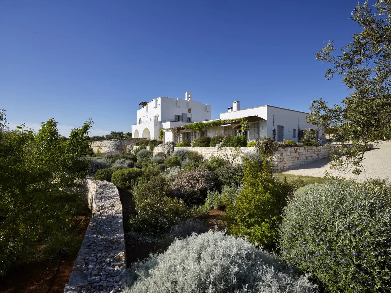 Masseria Monopoli garden facade with whitewashed tower and Mediterranean planting, Monopoli, Puglia, Italy