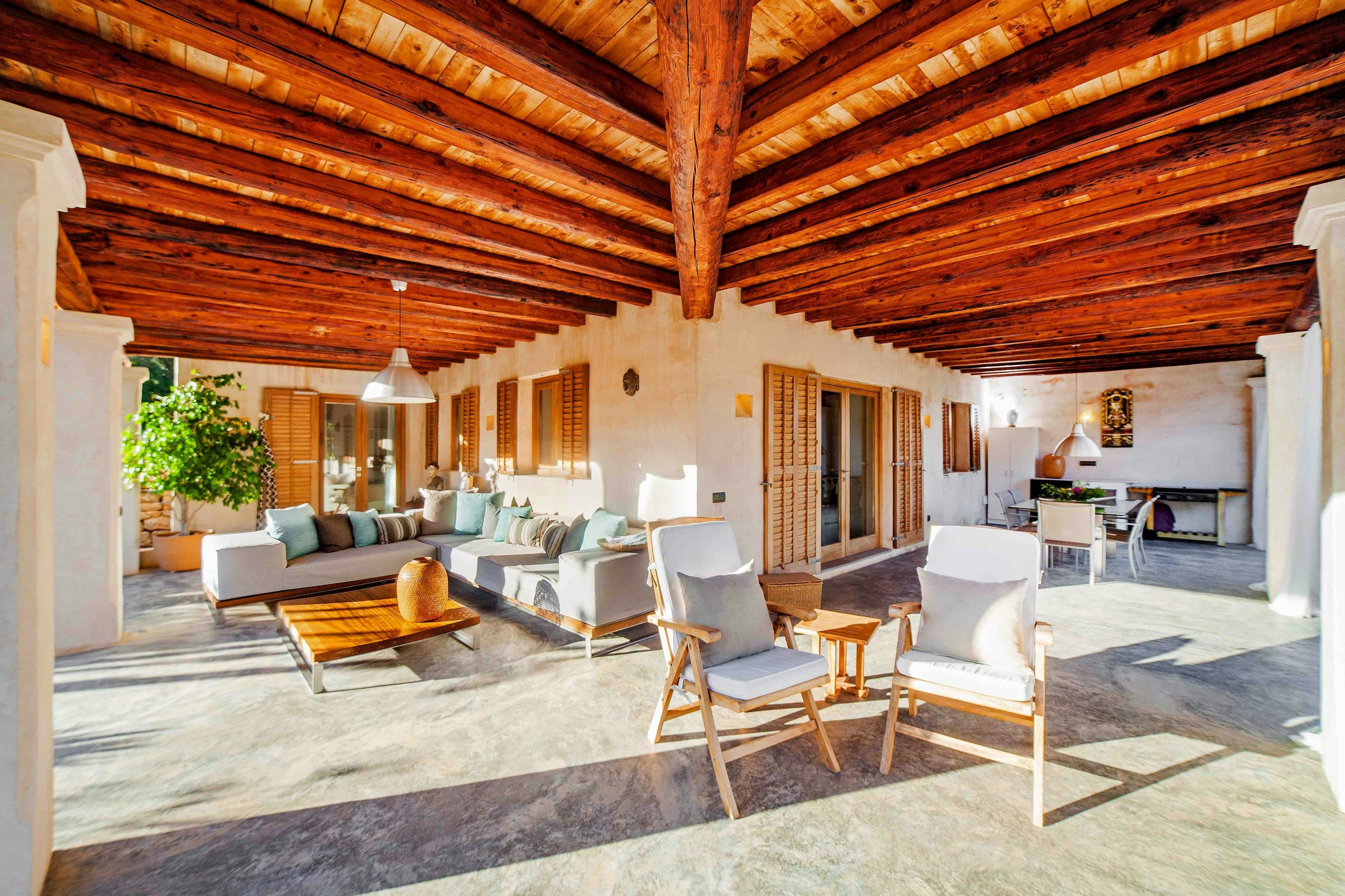 Almond Flower villa covered terrace with wooden beams and outdoor seating, Sant Antoni de Portmany, Spain