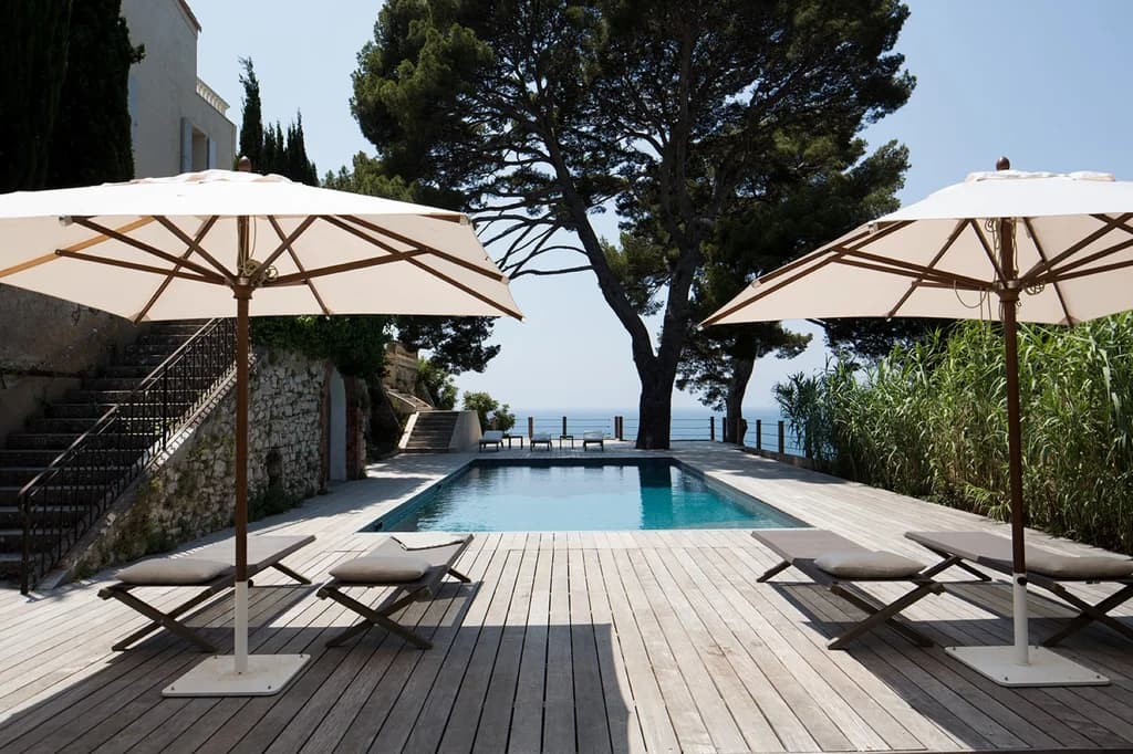 Villa Cassis pool deck lounge with teak sun loungers and linen parasols, Cassis, France