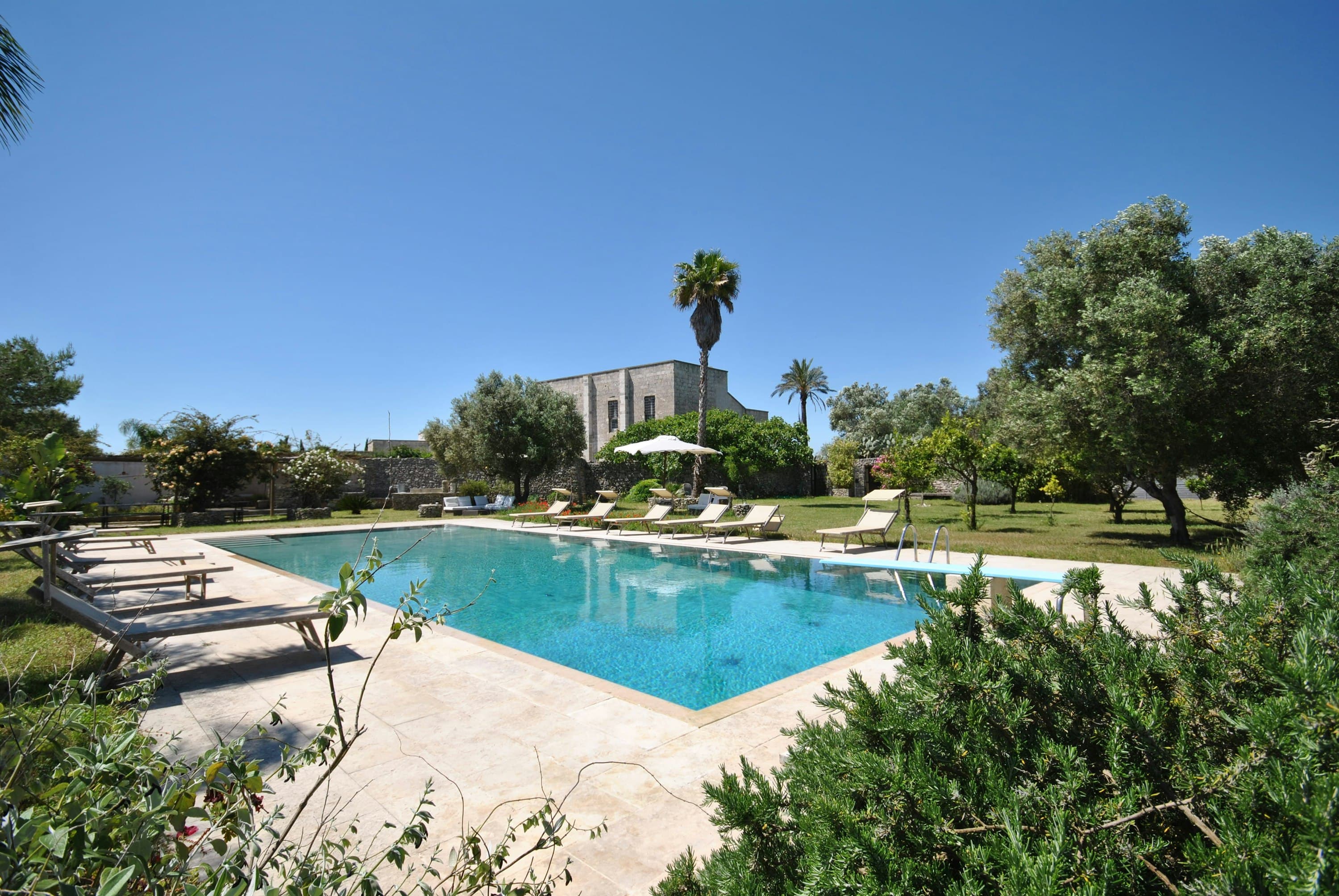 The Wise Soul villa exterior with rectangular pool and palm gardens, Lecce, Puglia, Italy
