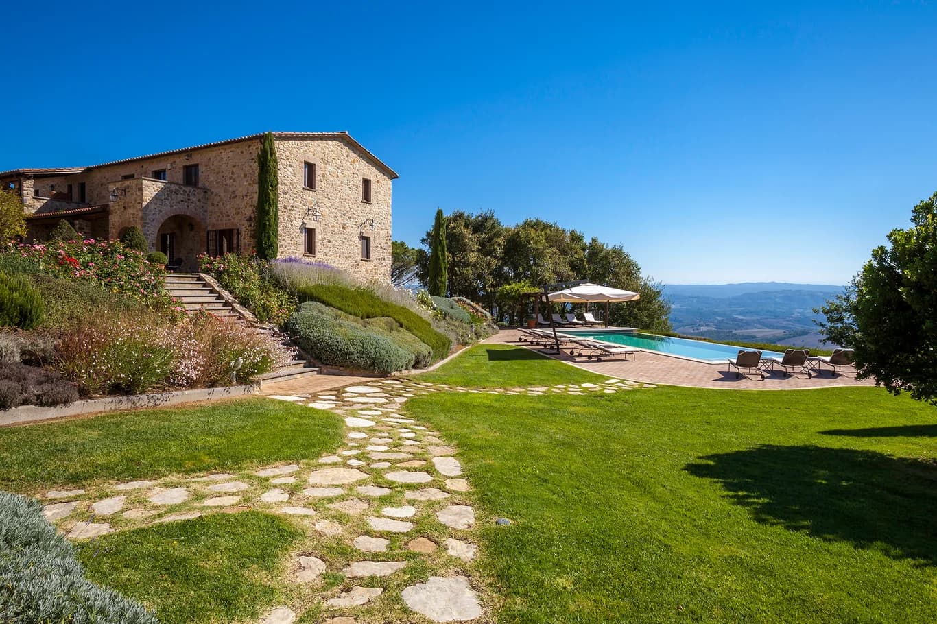 Villa Chianina historic stone farmhouse exterior with lavender terraces and Umbrian hills, Fabro, Italy