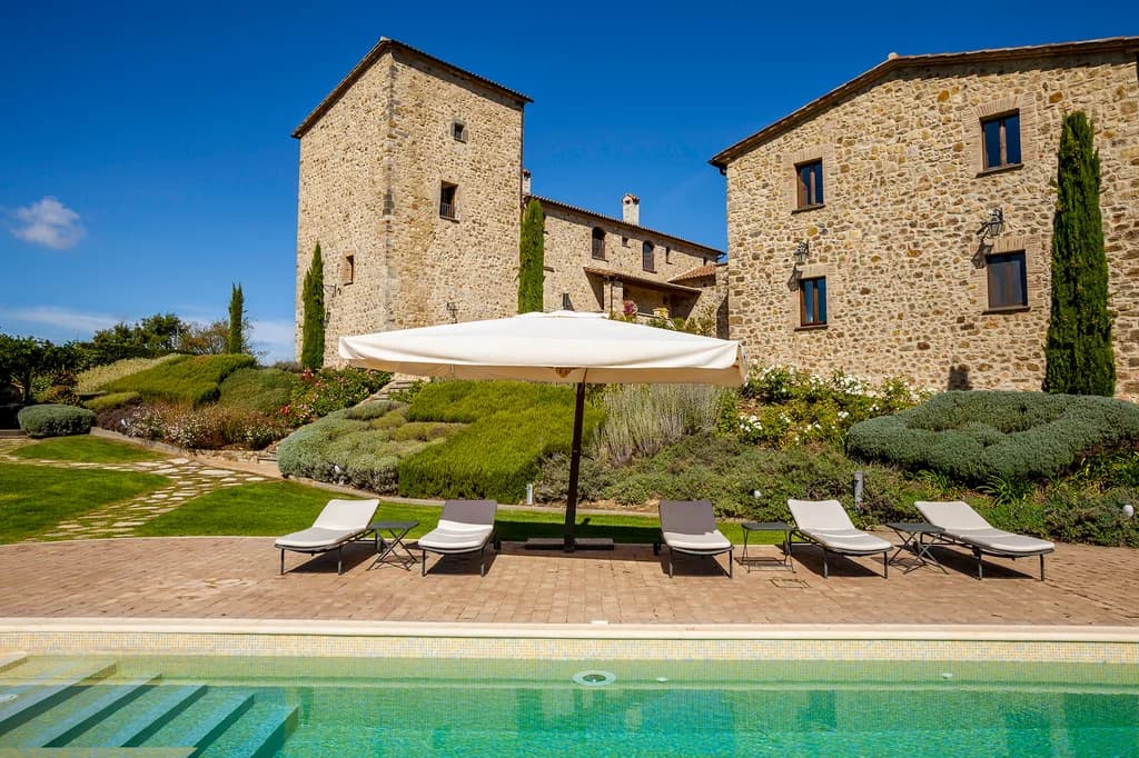 Villa Chianina outdoor mosaic-tiled pool beside medieval stone tower and lavender terraces, Fabro, Italy