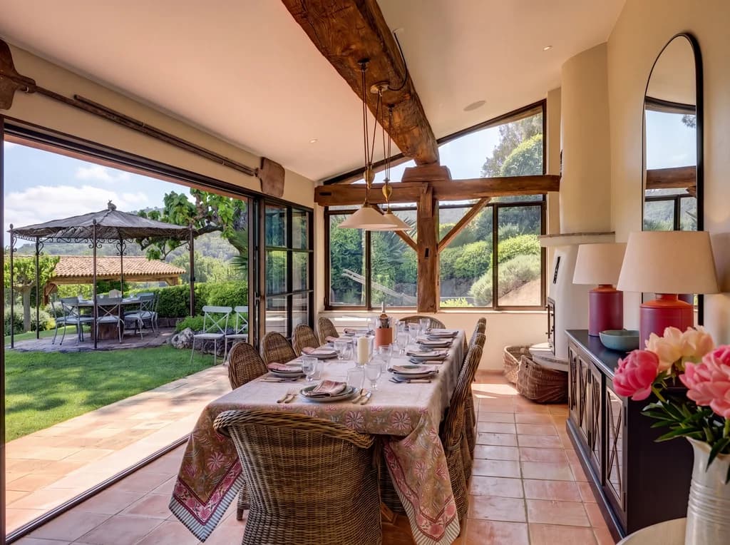Villa Vignoble indoor dining room with timber beams and garden doors, Grimaud, France