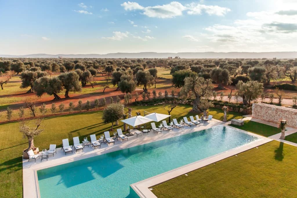 La Residenza lap pool with white loungers and olive trees, Savelletri, Puglia, Italy