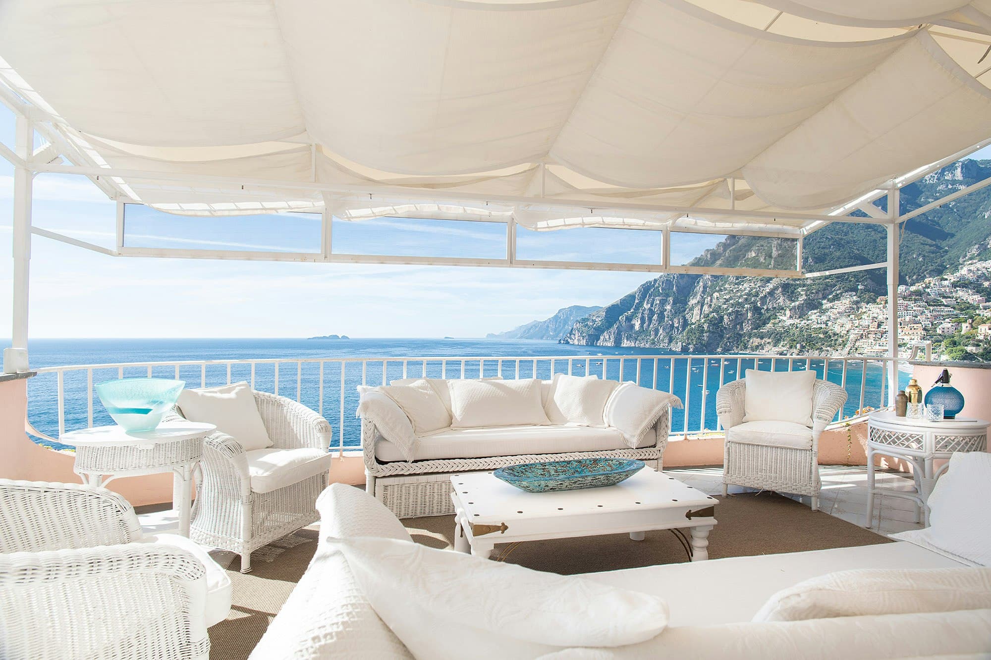 The Sunlit Cliff covered terrace with white furnishings overlooking the sea, Positano, Italy