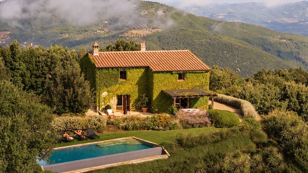 Villa Elceto aerial exterior view, ivy-covered stone villa amid ancient forest, Umbertide, Italy